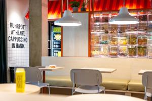 ボーフムにあるSTAYERY Bochum Ehrenfeldのテーブルと椅子のあるファーストフードレストラン