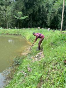a man standing by a river with a stick at Posada El Remolino in Anolaima