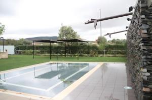 a swimming pool in a yard with a stone wall at Sierra Quilama in San Miguel de Valero