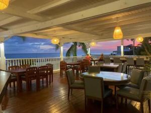 een restaurant met tafels en stoelen en uitzicht op de oceaan bij Modern apartment with sea view in Cupecoy in Cupecoy