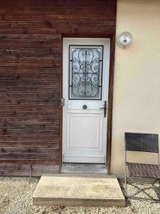 a white door with a window on a house at Charmant studio près de Sancheville - 27 m² - 2 pers in Bercis