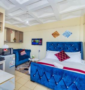 Bett mit blauem Kopfteil in einem Zimmer in der Unterkunft Executive Studio Serenity in Eldoret in Eldoret