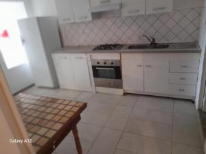 a small kitchen with white cabinets and a sink at Maison agréable à Bellerive-sur-Allier 70 m² in Charmeil