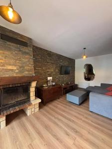 a living room with a couch and a fireplace at Maison cosy à Meaulne-Vitray avec jardin in Meaulne