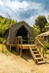 Una tienda de campaña con una cama y sillas dentro en Safari Glamping Portugal Koi Fish, en Ventosa