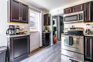 a kitchen with stainless steel appliances and wooden cabinets at Short North Convention Private Parking Pets in Columbus +72 photos