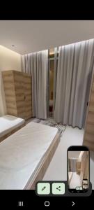 a small room with two beds and a mirror at ماجيك سويت السالمية 33 Magic Suite AlSalmiya 33 in Kuwait