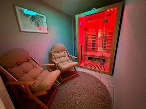 a room with two chairs and a window with red light at Elbflorenz in Bad Schandau