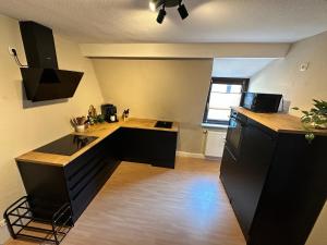a kitchen with black cabinets and a wooden floor at Elbflorenz in Bad Schandau +7 photos