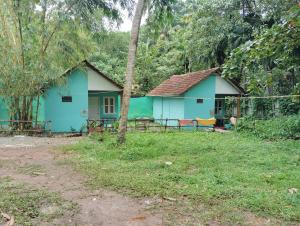 a blue house in the middle of a field at Macaw nest varkala in Varkala