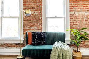 a green couch in a living room with windows at Prime Location Top Rated Clean Parking Free! in Columbus +136 photos