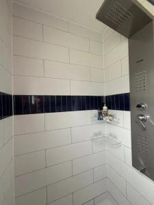 a bathroom with a shower with black and white tiles at Maison cosy à Meaulne-Vitray avec jardin in Meaulne