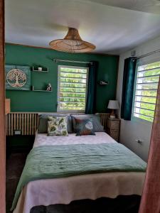 a bedroom with a large bed with green walls at Cozy House with Terrace in Upper Prince's Quarter in Upper Prince's Quarter