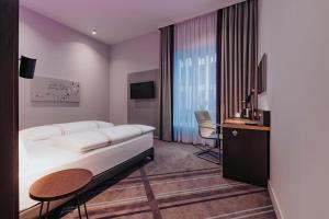 a hotel room with a bed and a desk at Premier Inn Rosenheim City Lokhöfe in Rosenheim