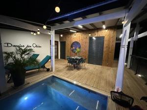 a house with a swimming pool and a patio at Bungalow romantique à Deshaies + piscine in Deshaies