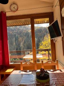 a dining room table with a view of a window at Studio panoramique Notre-Dame-de-Bellecombe - 20 m² - balcon sud in Notre-Dame-de-Bellecombe