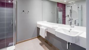 a white bathroom with a sink and a shower at Premier Inn Nürnberg City Opernhaus in Nürnberg +14 photos