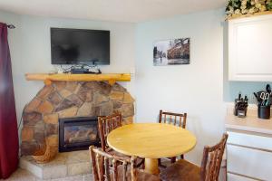 a dining room with a table and a fireplace at Scandinavian Lodge 203 in Steamboat Springs +11 photos