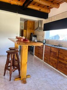 a kitchen with a wooden island in the middle at Cabaña Macar in Caviahue
