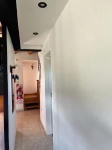 a hallway with a white wall and a door at Cabaña Macar in Caviahue +1 photo