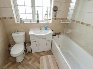 ein Badezimmer mit Toilette, Waschbecken und Badewanne in der Unterkunft 5 Links Court in Skegness + 9 Fotos