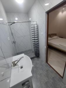 a bathroom with a sink and a mirror and a bed at Silk Road Guest House in Bukhara