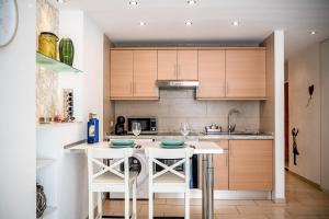 a kitchen with a white island with two stools at Apartamento Tenerife Sur in Playa de las Americas