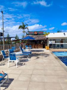 a swimming pool with blue chairs and a resort at Arraial do Cabo - Golden Lake in Arraial do Cabo