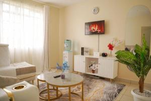 a living room with a couch and a table at Studio Executive Serenity in Eldoret in Eldoret