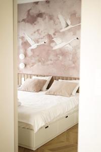a bedroom with a bed with birds wall mural at Apartament 22 in Boszkowo-Letnisko