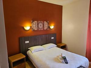 Un dormitorio con una cama con dos luces en la pared. en Domaine du Bocage, en Chavagnes-en-Paillers