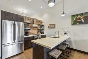 a kitchen with a stainless steel refrigerator and wooden cabinets at 2nd Street Lofts 209 in Whitefish