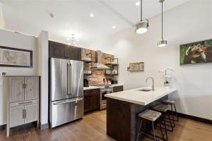 a kitchen with a stainless steel refrigerator and wooden cabinets at 2nd Street Lofts 209 in Whitefish