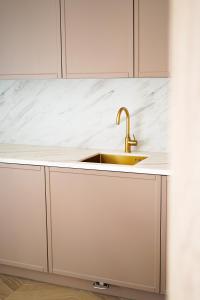 a kitchen with a sink and white cabinets at Apartament 22 in Boszkowo-Letnisko