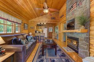 a living room with a stone fireplace in a log cabin at Unforgettable Dreams By Avada Properties in Catlettsburg
