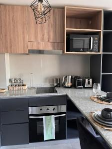 eine Küche mit Theke mit Herd und Mikrowelle in der Unterkunft Estadio Nacional Ñuñoa in Santiago + 2 Fotos