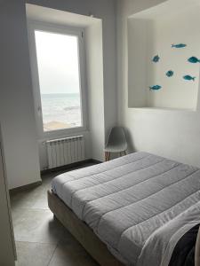 a bedroom with a bed and a window with the ocean at La casetta di Marta sul mare in Imperia