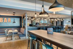 a bar with chairs and a table in a restaurant at Premier Inn Frankfurt Westend in Frankfurt/Main