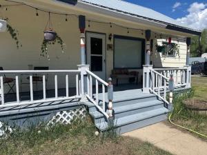 a house with a porch with a white railing at The Homestead! Stylish Escape with Scenic Views in Buena Vista