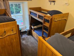 a room with two bunk beds and a window at The White Hart Inn & Bunkhouse in Moffat