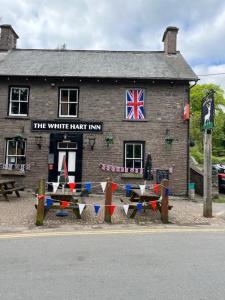 a brick building with a white hat inn with a flag at The White Hart Inn & Bunkhouse in Moffat