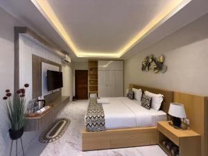a bedroom with a large bed and a television at Mara inn in Nusa Dua