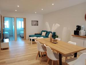 a living room with a table and a blue couch at Le Pérouges 3ch proche toutes commodités in Meximieux +3 photos