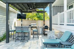 a patio with chairs and a bar with a tv at Exudes the Posh Life Heated Pool Fireplace & Stunning in Galveston