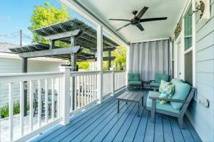 a porch with two chairs and a ceiling fan at Exudes the Posh Life Heated Pool Fireplace & Stunning in Galveston