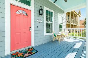 a red door on a house with a table and chairs at Exudes the Posh Life Heated Pool Fireplace & Stunning in Galveston +33 photos
