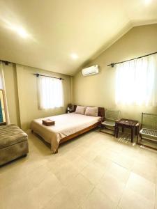 a bedroom with a large bed and two chairs at Biển house in Ấp Khánh Phước (1)