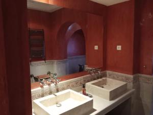 baño con 2 lavabos y pared roja en Dar El kharrouba, en Hammamet Nord 11 fotos más