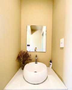a bathroom with a white sink and a mirror at Biển house in Ấp Khánh Phước (1)