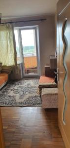 a room with two beds and a door with a window at Cozy room with balcony in Visaginas in Visaginas